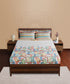 Bed with colorful geometric patterned bedspread in a bedroom setting.